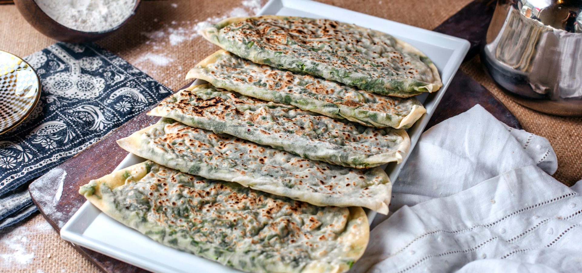 front-view-yummy-qutabs-with-green-herbs-inside-brown-floor