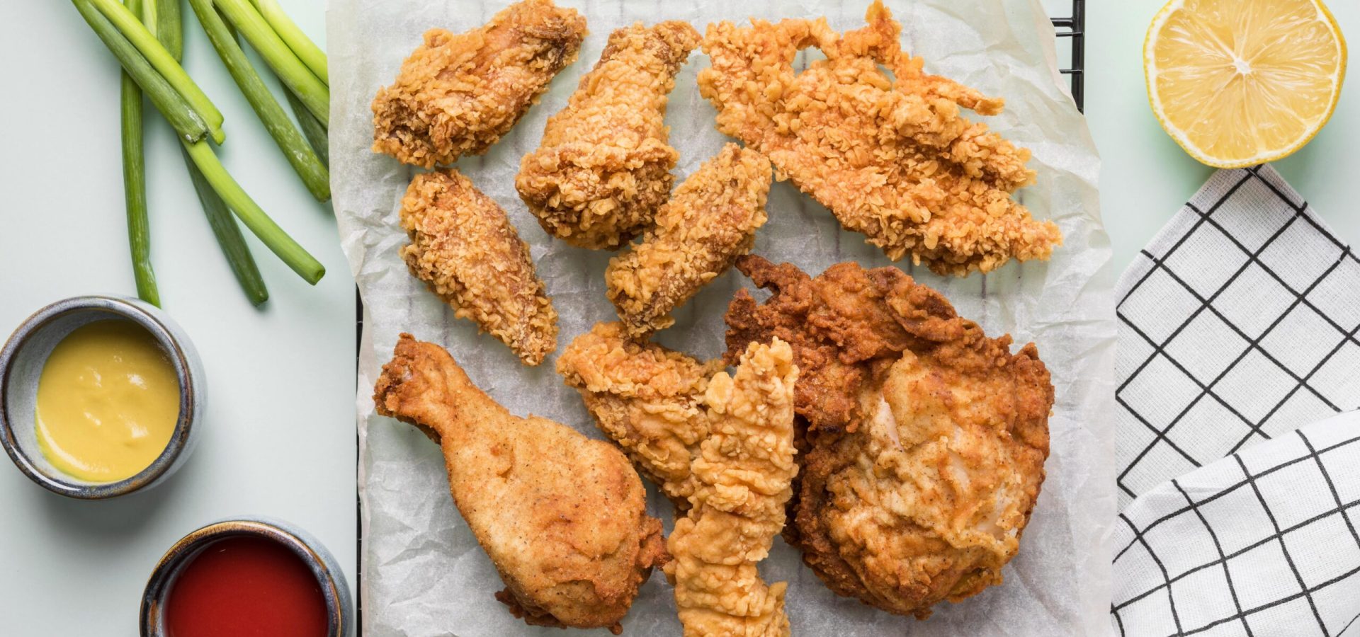 top-view-fried-chicken-tray-with-sauces-green-onions-lemon