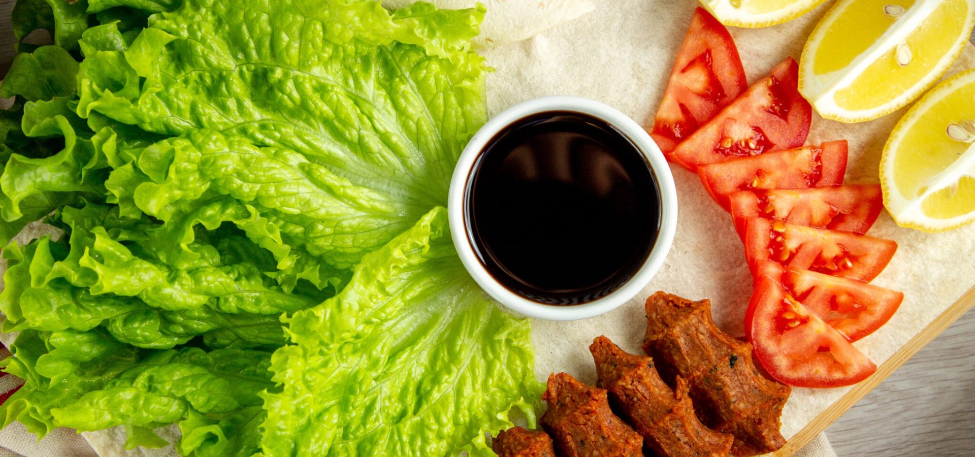 turkish kofte  meat  lettuce  tomato  lemon  top view